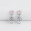 A pair of silver-toned dangle earrings featuring square pale pink stones surrounded by small clear stones, with ornate filigree drops and teardrop-shaped clear stones below, shown on a clean light gray background.