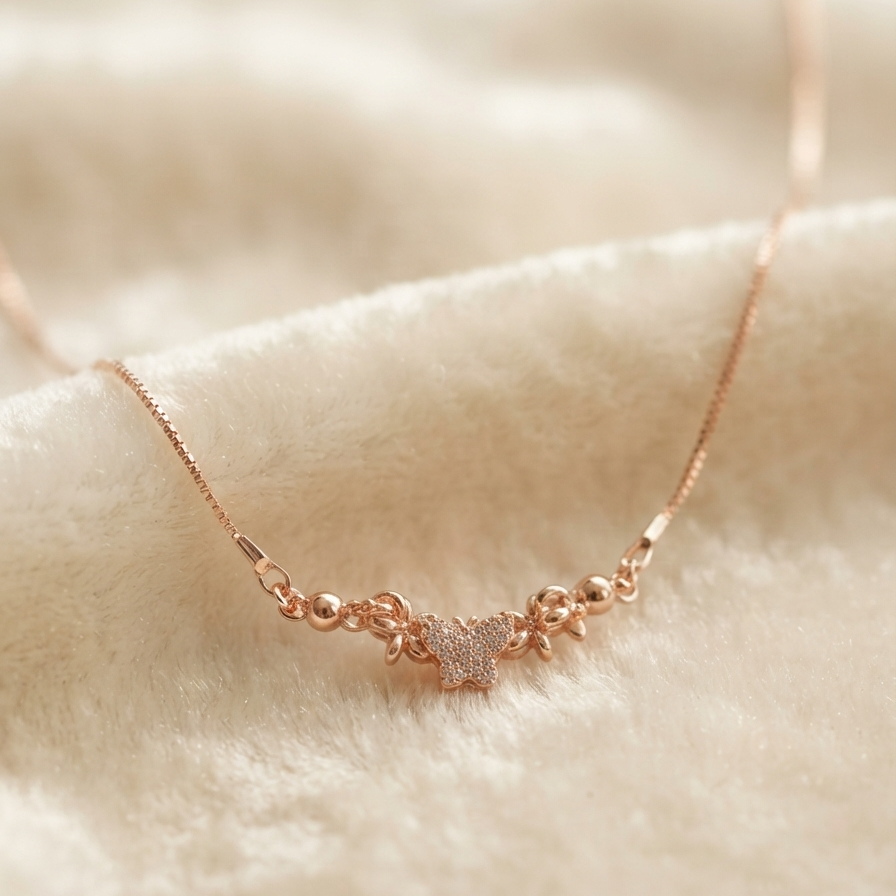 A delicate rose gold necklace with a small central charm, resting on a soft, textured cream-colored fabric background.